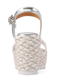 Sandali con tacchi metallici argento, realizzati con materiale intrecciato bianco e beige, dotati di una fascia con fibbia e una base piatta spessa e solida.