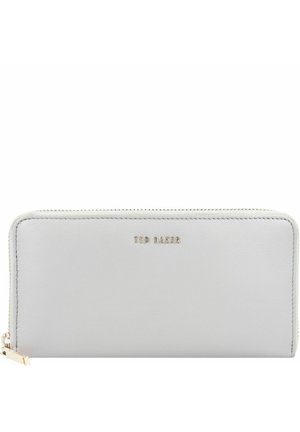 Cartera rectangular blanca con cierre de cremallera alrededor, tirador de cremallera dorado y pequeño logo "Ted Baker" centrado en el frente.