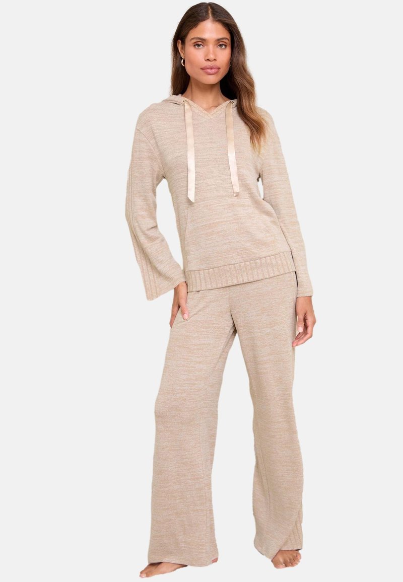 Vaaleanbeige loungewear-setti, joka koostuu hupullisesta pitkähihaisesta paidasta, jossa on satiininarut, ja leveälahkeisista housuista, joissa on samanlainen rakenne.