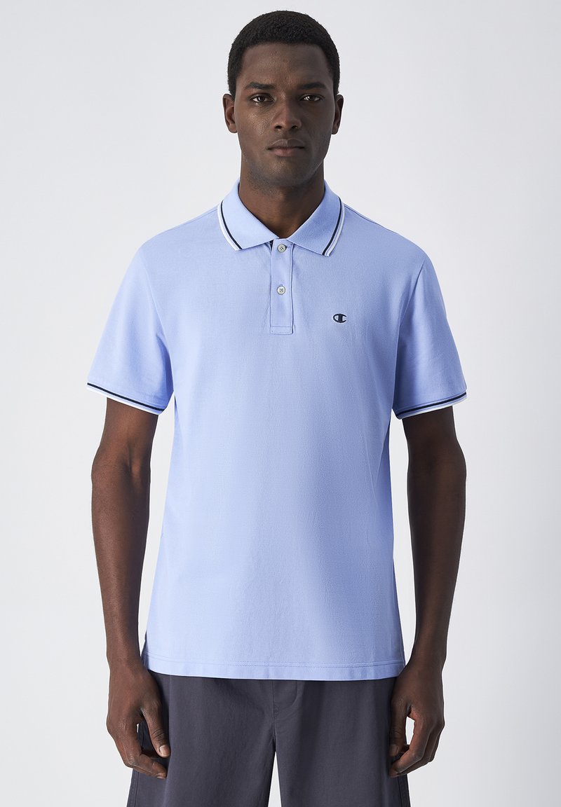 Jasnoniebieska koszulka polo z gładkiego materiału, z plastronem na dwa guziki, czarno-białymi wykończeniami kołnierzyka i rękawów oraz logiem.