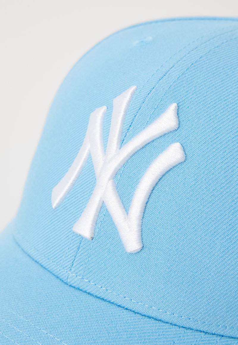 Gorra de color azul claro hecha de tela, con un logo de Nueva York bordado en blanco en la parte frontal. Diseño estructurado con visera curva.