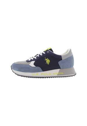 Zapatillas con una parte superior de ante en azul marino y azul claro, acentos blancos y una suela texturizada en gris; presenta un logo amarillo en el lado.