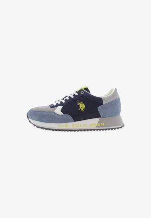 Zapatillas con una parte superior de ante en azul marino y azul claro, acentos blancos y una suela texturizada en gris; presenta un logo amarillo en el lado.