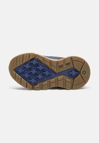 Suela de zapato de textil y goma azul, con un dibujo de banda de rodadura que presenta formas hexagonales y una suela exterior marrón. Ranuras texturizadas para una mejor tracción.