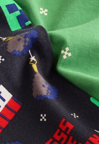Knitted fabric, featuring a black base with colorful pixelated designs, and a smooth green section. Notable patterns include game elements.