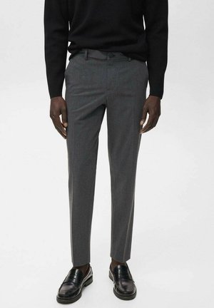 Grau maßgeschneiderte Hose mit feiner Textur, schlanker Schnitt und flachem Frontdesign, kombiniert mit schwarzen Mokassins und einem schwarzen Pullover.