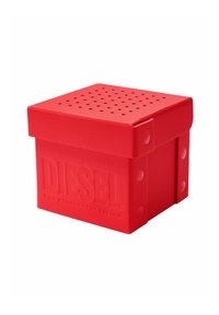 Enceinte de couleur rouge de marque Diesel avec un dessus perforé et une surface texturée, conçue comme un appareil audio portable compact.