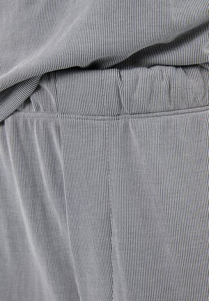 Tessuto a strisce grigie e bianche con una sottile trama, dotato di una vita elasticizzata e cuciture ordinate lungo le giunture.