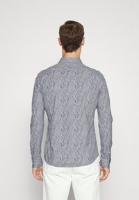 Lange mouwen shirt in marineblauw met een bladerenpatroon. Gemaakt van lichtgewicht stof, voorzien van een button-down kraag en manchetten met één knoop.