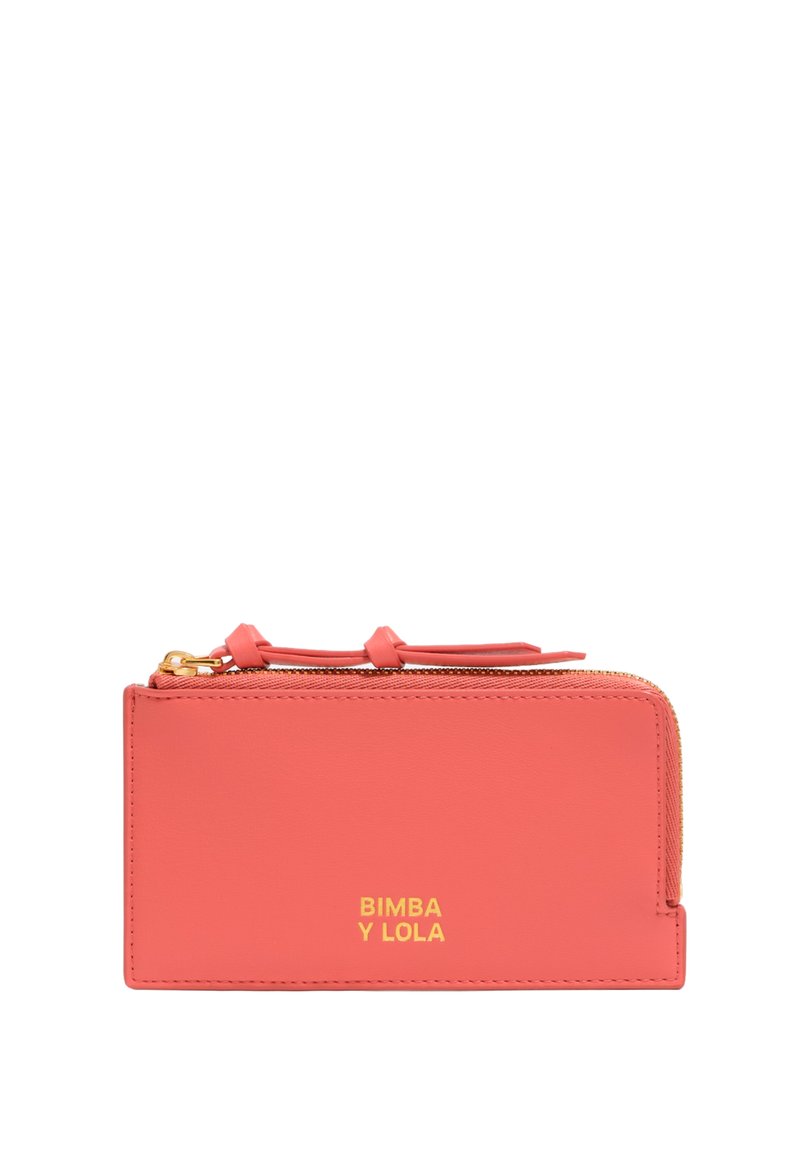 Cartera de cuero color coral con un cierre dorado, logo en relieve, diseño plano y estética minimalista. Presenta un pequeño acento en forma de lazada.