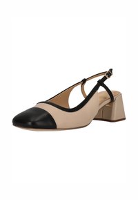 Beige en zwarte slingback schoen met een ronde neus, blokhak en uitsparingen. Gemaakt van soepel leer met minimale hardware.