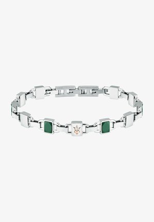 Strieborný kovový náramok so štvorcovými zelenými akcentmi a centrálnym logom. Dizajn obsahuje prepojené články reťaze a lesklé povrchy.