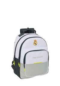 Zaino bianco e grigio con numerosi scomparti con zip, logo del Real Madrid sulla parte superiore e testo "Real Madrid" sulla tasca anteriore.