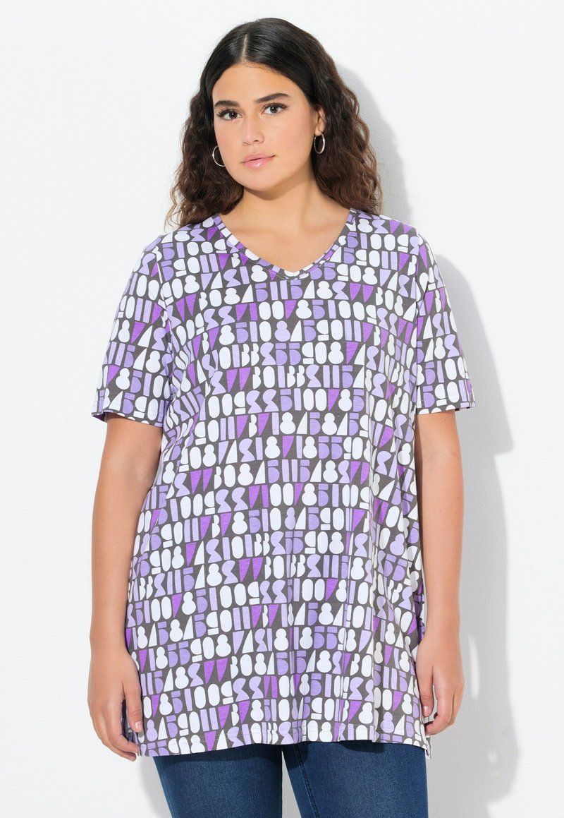 Paarse en witte geblokte T-shirt met korte mouwen en V-hals, voorzien van geometrische vormen op een grijze achtergrond; zachte stof, losvallend ontwerp.