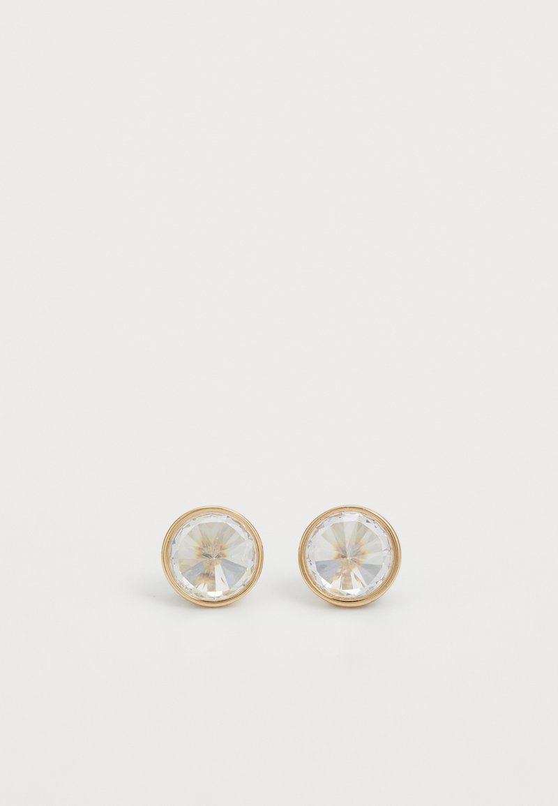 Gouden studs met ronde, facetterende heldere kristallen en een gladde metalen rand, die licht reflecteren met een subtiele glans.