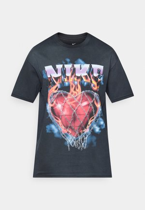 Camiseta de algodón negra con un gran gráfico que presenta la palabra "NIKE" y un diseño de corazón en llamas encerrado en cadenas, con acentos de nubes azules.