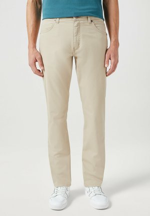 Beige katoenen chino's met een recht figuur, met voorzakken, een ritssluiting en een gestructureerde stof. Gecombineerd met witte sneakers.