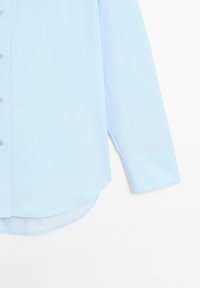 Lichtblauw overhemd met lange mouwen, gemaakt van zachte stof, met knoopsluiting aan de voorkant, afgeronde zoom en manchetten met één knoop.