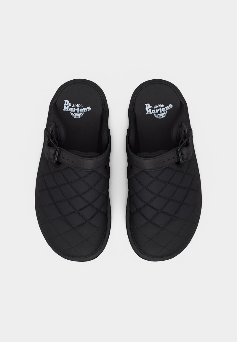 Schwarze, gesteppte Slip-on-Clogs mit verstellbaren seitlichen Riemen und weißem Dr. Martens AirWair Logo auf den Innensohlen, von oben auf weißem Hintergrund gesehen.