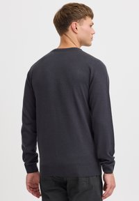 Dunkelgrauer gestrickter Pullover mit Rundhalsausschnitt, langen Ärmeln, gerippten Bündchen und Saum. Glatte Textur ohne zusätzliche Muster oder Akzente.