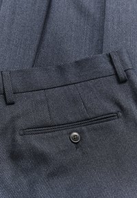 Tmavě modré kalhoty s jemným kostkovým vzorem, ušitým v elegantním střihu, a jednou zadní kapsou se čtyřdílným knoflíkovým zapínáním.