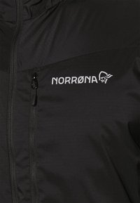 Black jacket featuring a prominent zipper and logo, constructed from lightweight material with a smooth texture and water-resistant finish.
