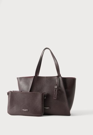 Sac fourre-tout en cuir texturé marron foncé avec petite pochette zippée assortie, tous deux avec des logos discrets de la marque sur un fond clair uni.
