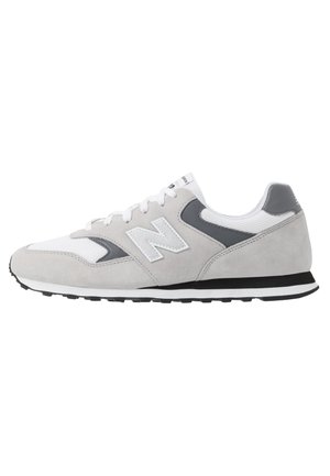 Szaro-białe buty sportowe New Balance zamszowe i z siateczki, czarno-biała podeszwa oraz logo z boku.
