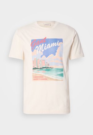 Kremfarget bomull T-skjorte med grafisk trykk av Miami-skyline, bølger og skyer i pastellfarger, med teksten "GANT Miami" og "Greetings From Florida".