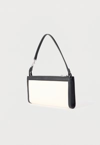 Ορθογώνια λευκή τσάντα χειρός με μαύρη επένδυση και ρυθμιζόμενο μαύρο λουρί ώμου, τοποθετημένη σε ανοιχτό, μονόχρωμο φόντο.