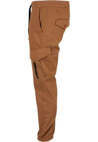 Pantalon cargo marron avec taille élastiquée et bas de jambes élastiqués, doté d'une poche latérale à rabat avec bouton et d'une poche cargo zippée.