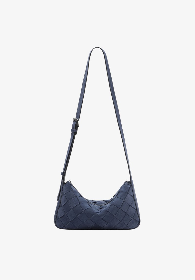Borsa in suede blu navy con texture intrecciata, forma asimmetrica, tracolla regolabile e chiusura con zip in cima. I dettagli includono bordi neri.