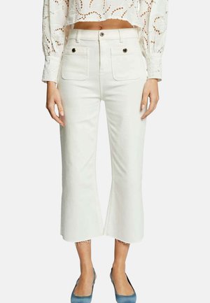 Jean blanc court à ourlet évasé, avec poches avant et deux boutons. Le matériau a une texture lisse et douce.