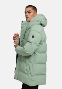 Mint zelena pufferska jakna s kapuco, s zadrgo, z gumbi na snap in logotipom na rokavu. Nežna tekstura in prešita zasnova.