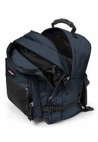 Sininen kangaskassi, jossa on useita lokeroita, vetoketjuja, verkkotasku ja kantokahva. Varustettu säädettävillä olkaimilla ja vahvistetulla pohjalla.