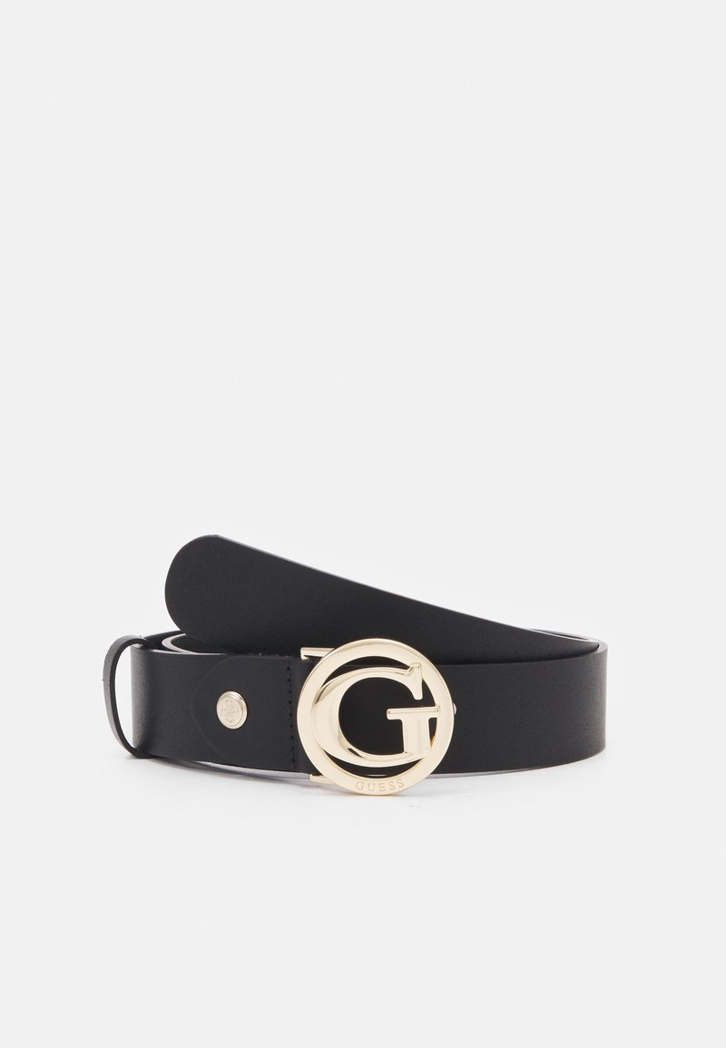 Ceinture en cuir noir avec une boucle ronde dorée portant un grand "G" et le nom de la marque "Guess" gravé sur la boucle.