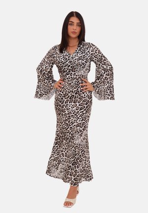 Maxikleid mit Leopardenprint und langen, ausgestellten Ärmeln. Hat ein tailliertes Oberteil und einen fließenden Rock in Schwarz- und Beigetönen. Dazu werden Sandalen getragen.