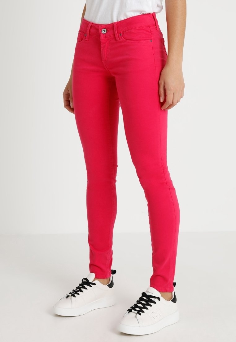Skinny Jeans aus dehnbarem, pinkem Stoff, mit figurbetontem Design, Fünf-Taschen-Stil und einem einzelnen Knopf- und Reißverschluss.