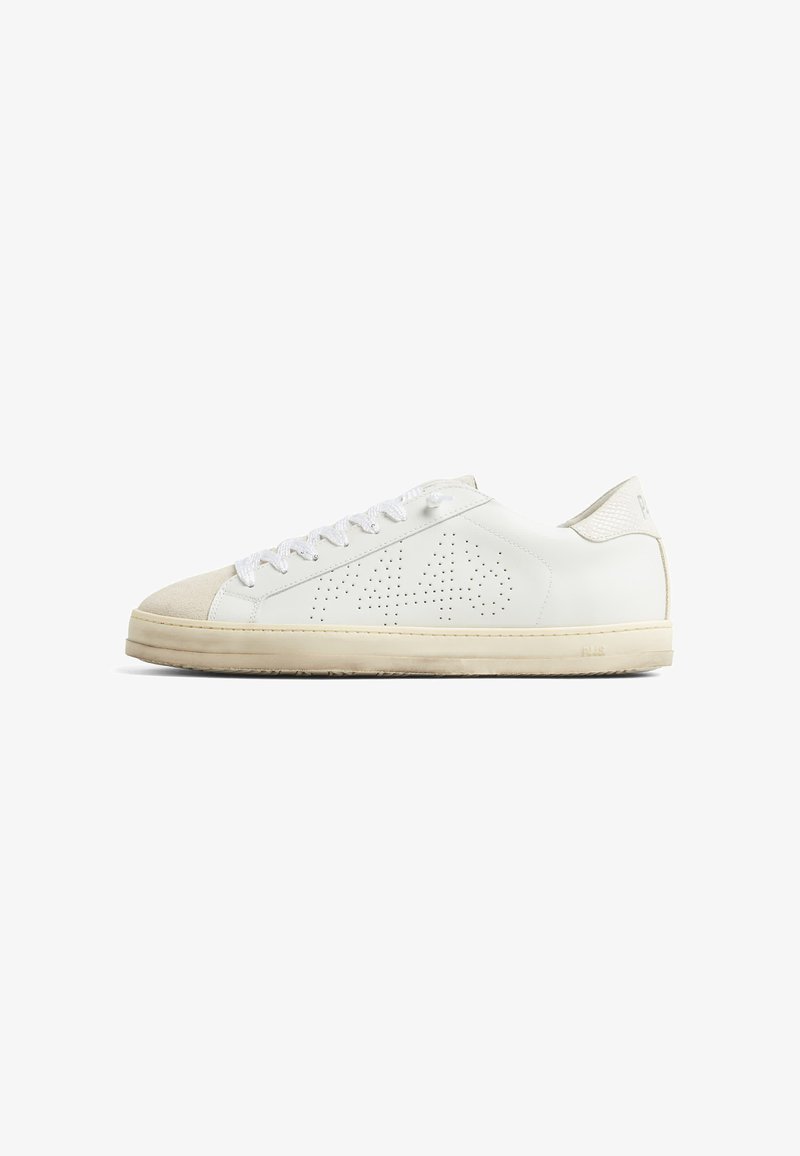 Baskets basses blanches avec semelle et bout beige, motif perforé "A" sur le côté et lacets blancs vus de l'extérieur.