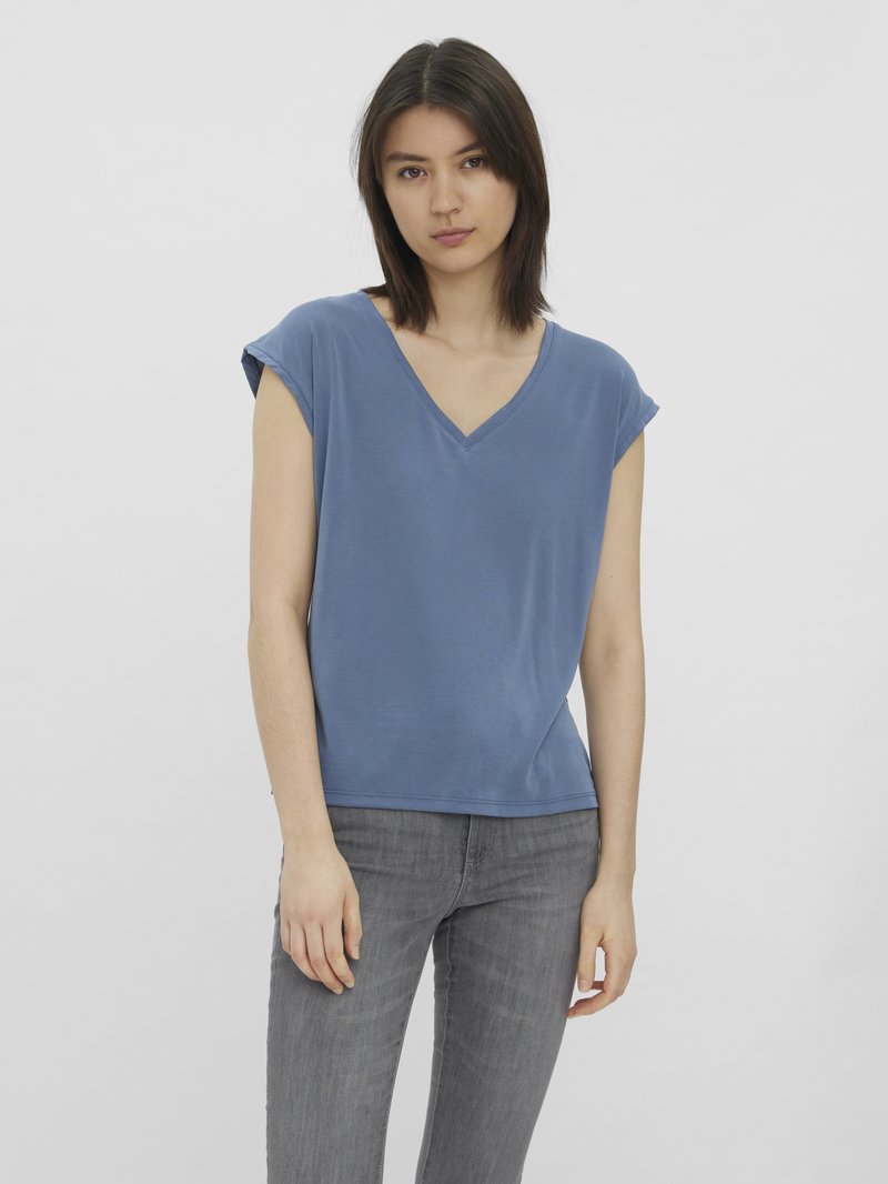 Blå bomull T-skjorte med V-hals, kortermet og en avslappet passform. Kombinert med grå slim jeans. Enkel design og myk tekstur.