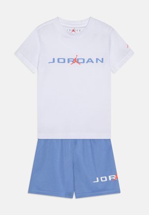 T-shirt bianca in cotone con logo "JORDAN" blu e accento rosso. Pantaloni corti blu coordinati con stampa "JORDAN" bianca. Entrambi hanno una vestibilità comoda.