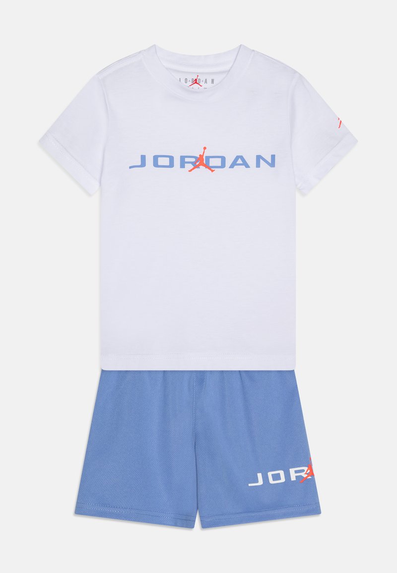 Λευκό βαμβακερό T-shirt με μπλε λογότυπο "JORDAN" και κόκκινη λεπτομέρεια. Συμβατά μπλε σορτς με λευκή εκτύπωση "JORDAN". Και τα δύο έχουν χαλαρή εφαρμογή.