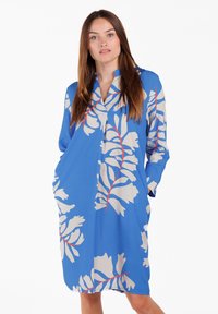 Blaues Kleid mit floralem Muster in Creme und Rot. Mit Kragen, langen Ärmeln und seitlichen Taschen. Glatter, leichter Stoff.