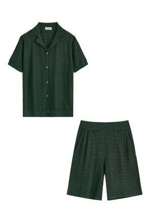 Chemise boutonnée à manches courtes vert foncé avec col et shorts en maille texturée assortis avec taille élastique et poches latérales.