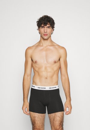 Schwarze Boxershorts mit einem weißen elastischen Bund, auf dem "ONLY & SONS" steht. Das Modell ist oberkörperfrei und zeigt eine sportliche Figur.