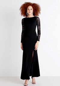 Black long-sleeve dress with lace sleeves, featuring a side slit and a fitted design. Smooth texture with a floor-length cut.