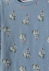 Tessuto azzurro chiaro con un motivo ripetuto di conigli grigi con orecchie rosa. La texture è liscia e il design include piccoli accenti bianchi.