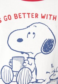 White T-shirt featuring a blue outline of a cartoon dog holding a dotted cup, with red text above saying "Life's better with."