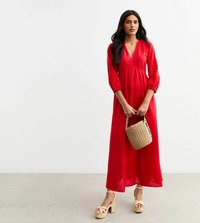 Röd maxiklänning med trekvartsärmar, djup V-ringning, lättviktsmaterial och subtil broderi. Matcher med beige plattformssandaler och en vävd väska.