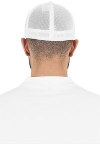 Hvit mesh trucker-caps med strukturert krone og buet skjerm, med en pustende bakpanel for ventilasjon.